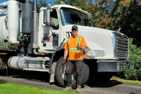 Clearset technician standing in front of a service truck before a mobile RV pump-out stop.